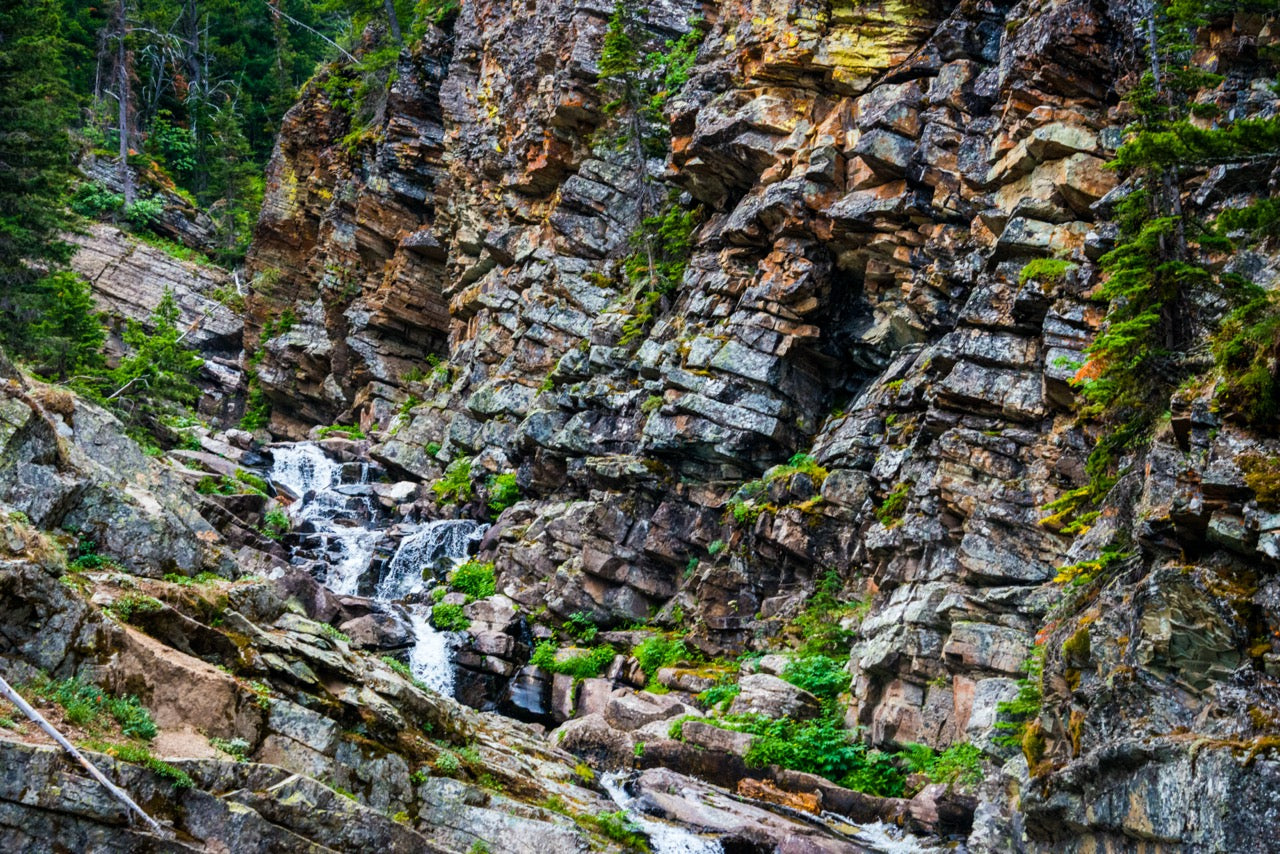 Blockstone Falls by Brady Iverson - A meandering waterfall next to a cliff of gray and yellow granite.