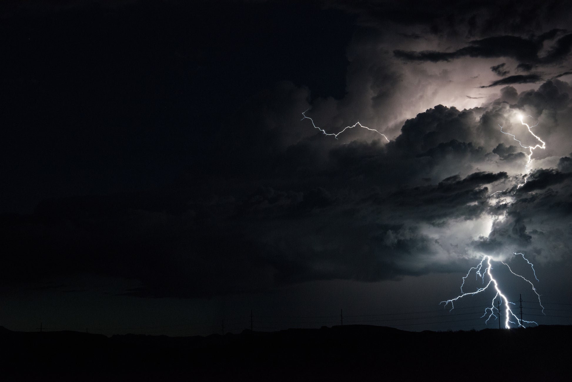 A rare and stunning lightning bolt strikes the earth in Southern utah. The bold weaves through the layers of thick, dark clouds, illuminating the paths and holes in the seemingly impenetrable clouds. 